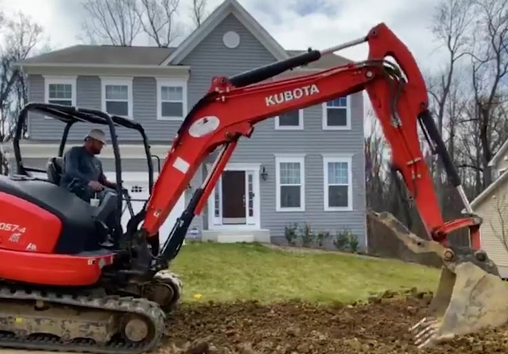 Man using a bulldozer to dig in a yard
