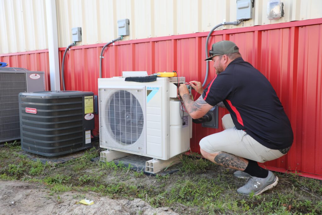 a man fixing an air conditioner outside