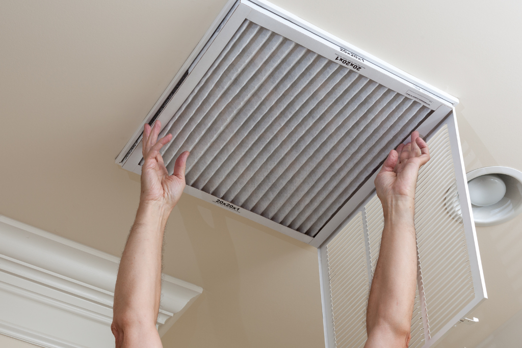a person is reaching up to a ceiling air conditioner