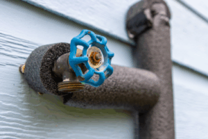 a close up of an insulated pipe with a blue spigot
