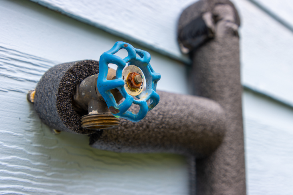 a close up of an insulated pipe with a blue spigot