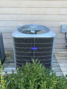 an air conditioner sitting on top of a wooden deck