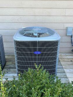 an air conditioner sitting on top of a wooden deck