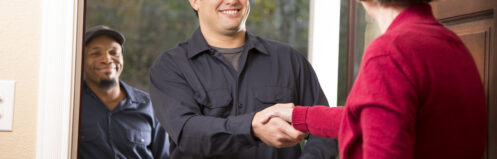 HVAC technician shaking hands with homeowner